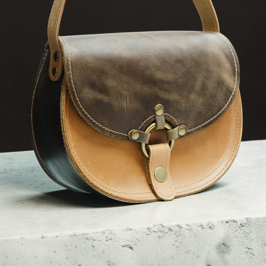 Handgefertigte runde Ledertasche mit Ringverschluss und klarer Satteltaschenform für Damen