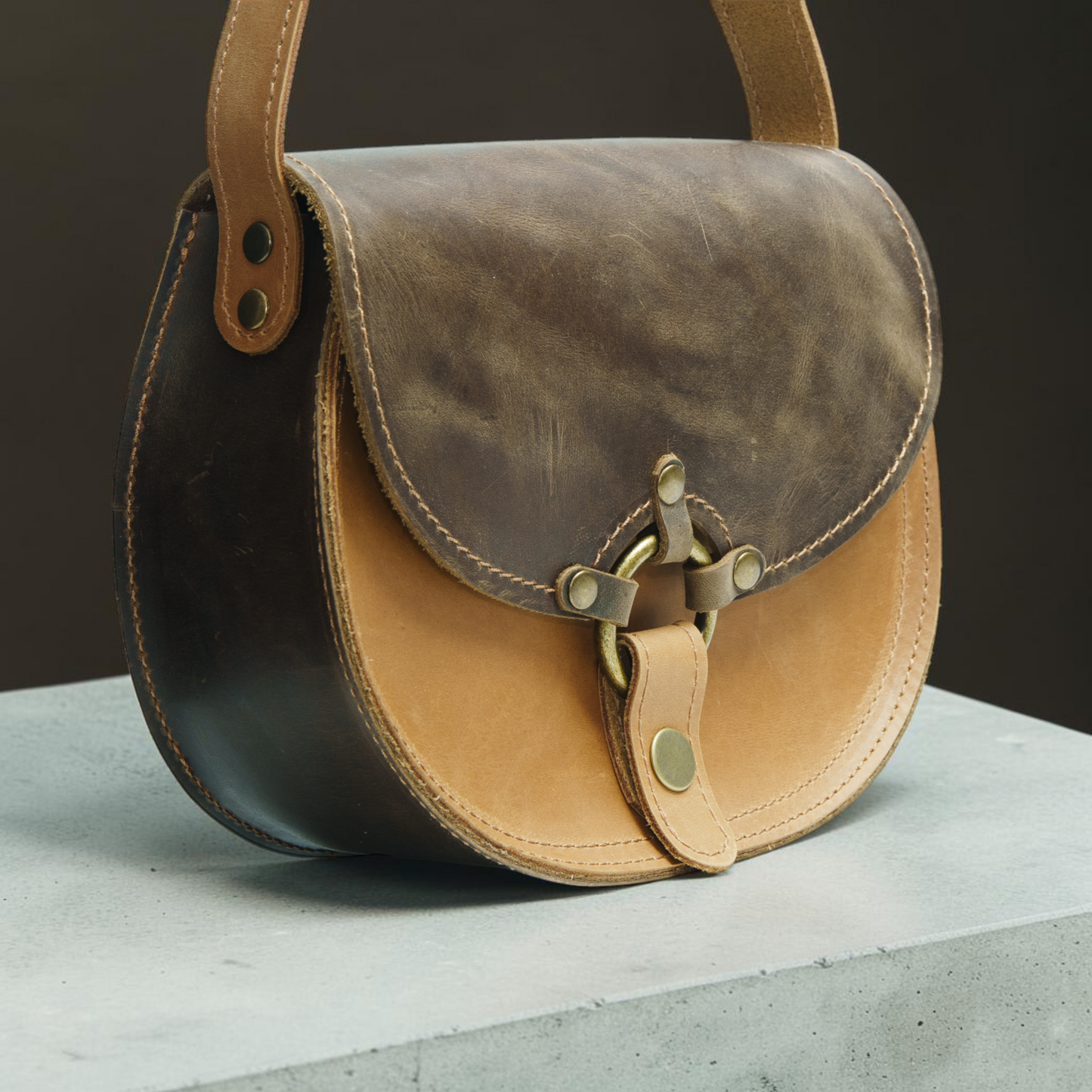 Handgefertigte runde Ledertasche mit Ringverschluss und klarer Satteltaschenform für Damen