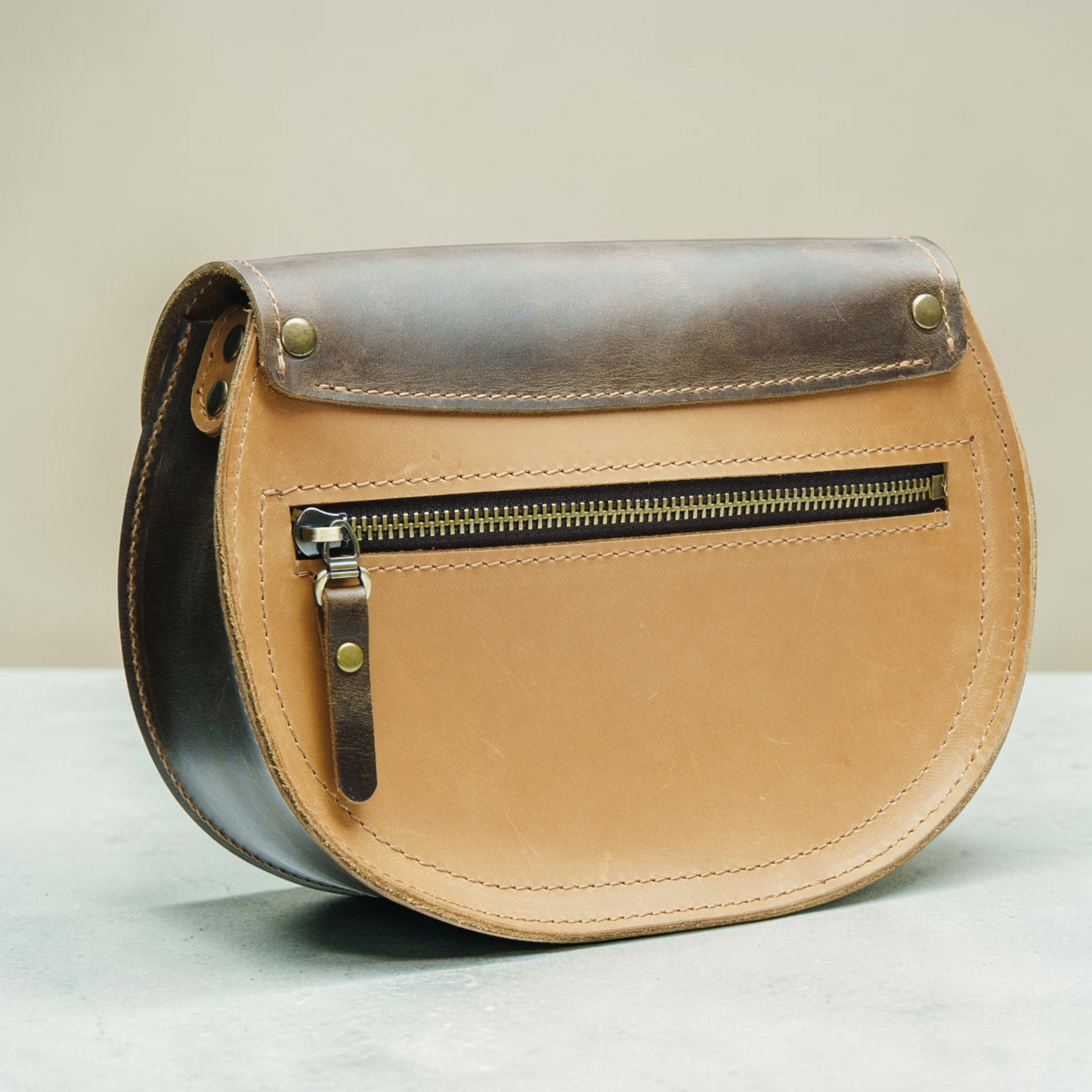 Handgefertigte runde Ledertasche mit Ringverschluss und klarer Satteltaschenform für Damen